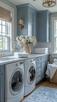 a washer and dryer in a blue laundry room with flowers on the counter