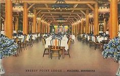 an old postcard shows tables and chairs in a restaurant with chandeliers hanging from the ceiling