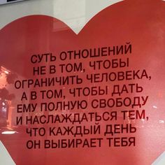 a red heart shaped sign with words written in russian and english on the front side