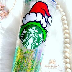 the starbucks cup is decorated with glitter and santa's hat