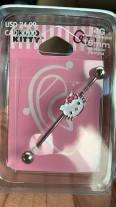 a pink package with a hello kitty design on it's side and a metal barbell clip in the middle