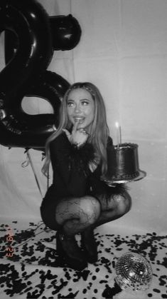 a woman sitting on the floor with a cake and candles in front of her face