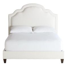 a bed with white linens and pillows on it's headboard, against a white background