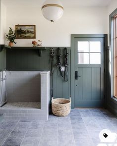 a bathroom with gray tile and green doors