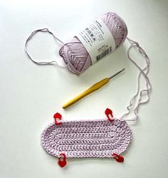 a crocheted object with yarn and knitting needles