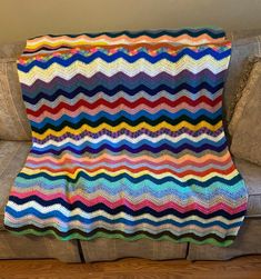 a multicolored crocheted blanket sitting on top of a couch