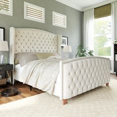 a white bed sitting in a bedroom on top of a hard wood floor next to a window