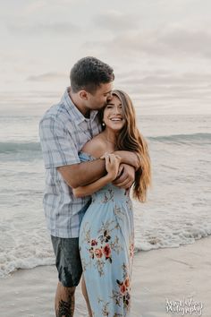 a man and woman hugging on the beach