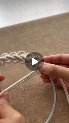two hands are working on a piece of string