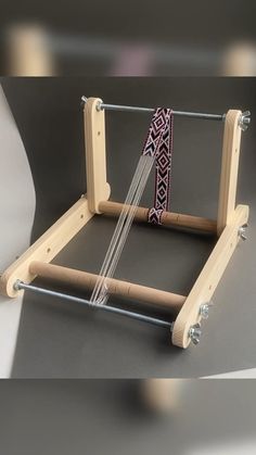 an image of a weaving machine on the table with it's wooden frame and handle