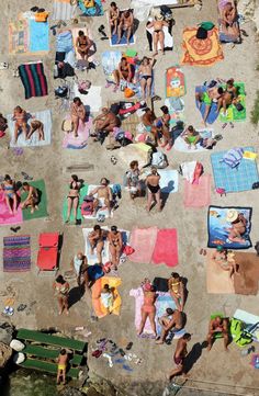 many people are laying on towels at the beach