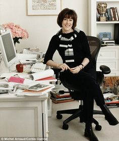 a woman sitting in an office chair next to a desk