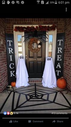 two halloween decorations on the front door of a house with ghost faces and pumpkins