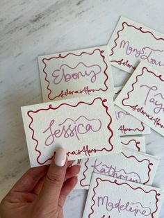 four handwritten business cards in different colors