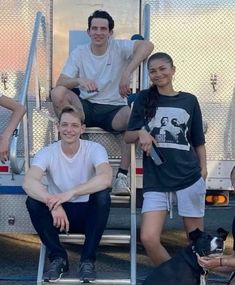 a group of people sitting next to each other in front of a firetruck