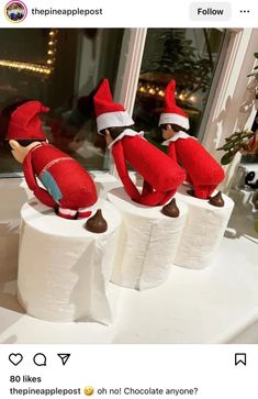 three elfs sitting on top of toilet paper rolls