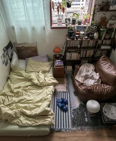 a small bedroom with a bed, couch and bookshelf in it's corner
