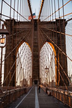 two people walking across the brooklyn bridge