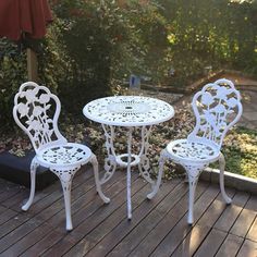 an outdoor table and two chairs on a deck