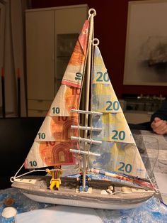 a model sailboat made out of money sitting on top of a table