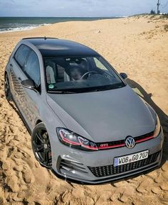 a grey car parked on top of a sandy beach