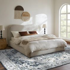 a large bed sitting on top of a wooden floor next to a tall white wall