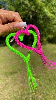 a hand holding a string heart shaped kite