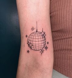a woman's arm with a small globe tattoo on it