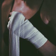 a man with bandages on his arm holding onto a white piece of cloth that he is wearing