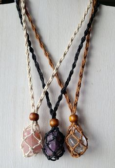 three different necklaces are hanging on a piece of cloth with beads and wood bead