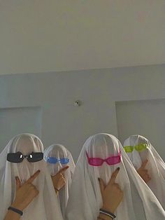 four women wearing blindfolds with their fingers up