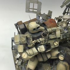 a toy warhammer is sitting on top of some rubble and it looks like he's about to fall