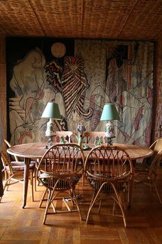 a dining room table and chairs in front of a mural