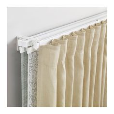 curtains hanging on the side of a wall with white trimmings and an open curtain rod