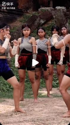 a group of people standing next to each other in front of trees and rocks with their hands together