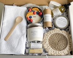 an open box containing various items such as candles, strawberries, yogurt and more