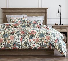 a bed with a floral comforter and pillows