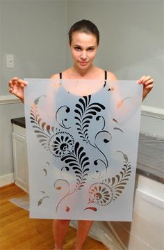 a woman holding up a white sign with black designs on it