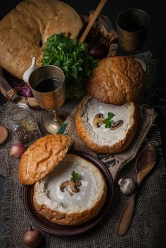 an assortment of breads, mushrooms and other food items on a table with utensils