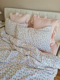 an unmade bed with pink and white sheets