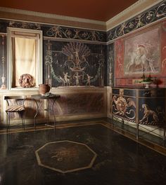 an ornately decorated room with paintings on the walls and floor, along with two chairs