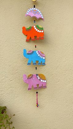 three colorful elephants are hanging on the wall