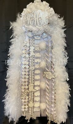 a white feather jacket with the word monogrammed on it and some other letters