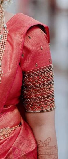 a woman wearing a pink sari and jewelry