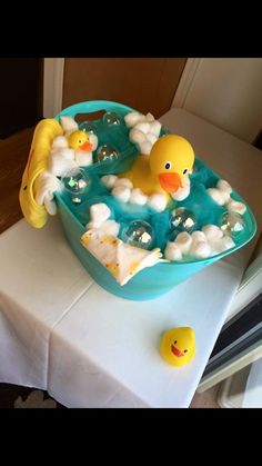 a bathtub cake with rubber ducks and bubbles in it on top of a table