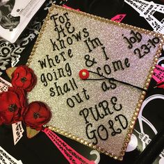 a graduation cap with writing on it and red flowers in the corner next to it
