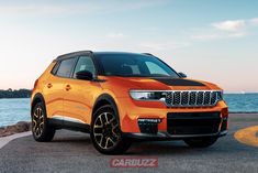 an orange jeep is parked near the water