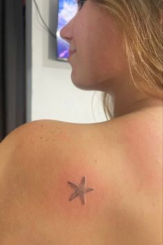 a woman with a small star tattoo on her back