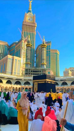 many people are sitting on the ground in front of some buildings