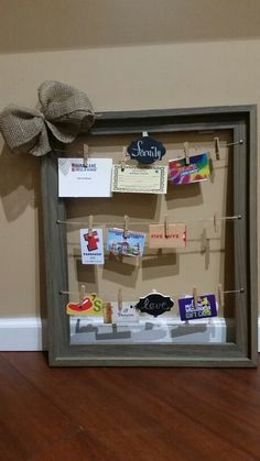 a bulletin board with clothes pins and magnets attached to it on a wooden floor